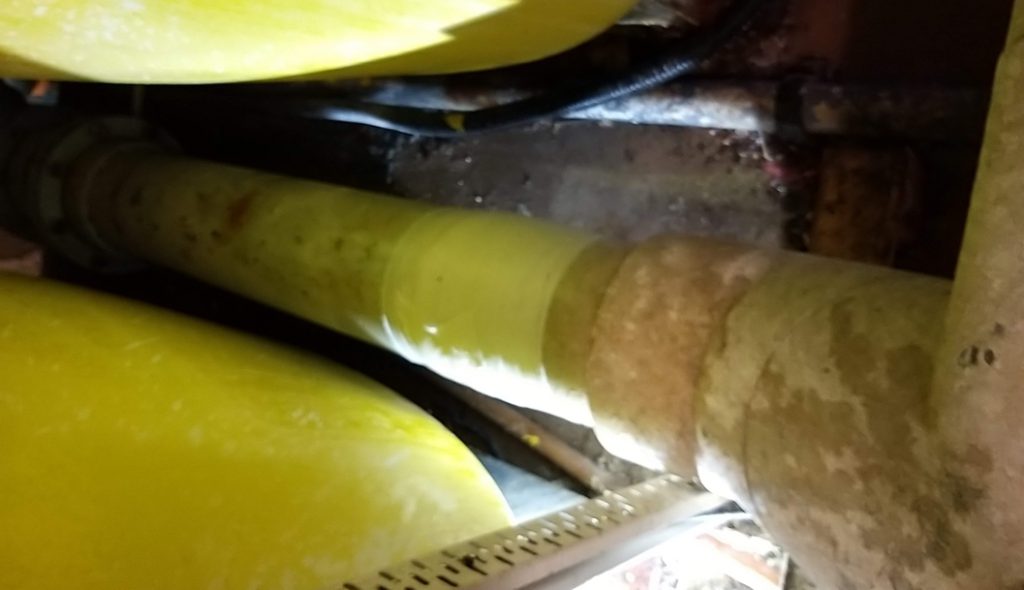 A cracked plastic pipe in a swimming pool filtration system having undergone repair with a SylWrap Pipe Repair Kit