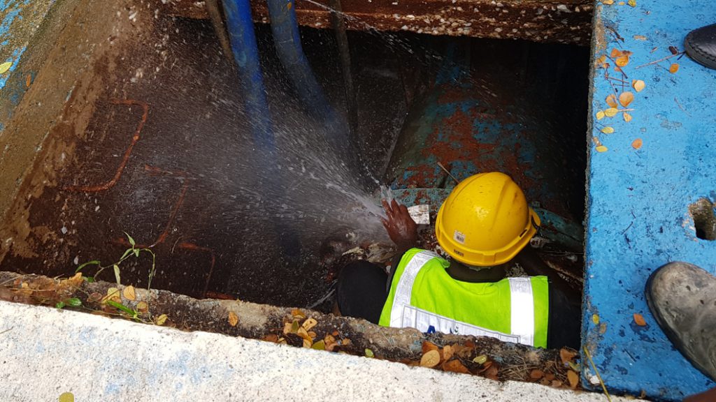 An underground water main in a flooded chamber in Malaysia undergoes repair