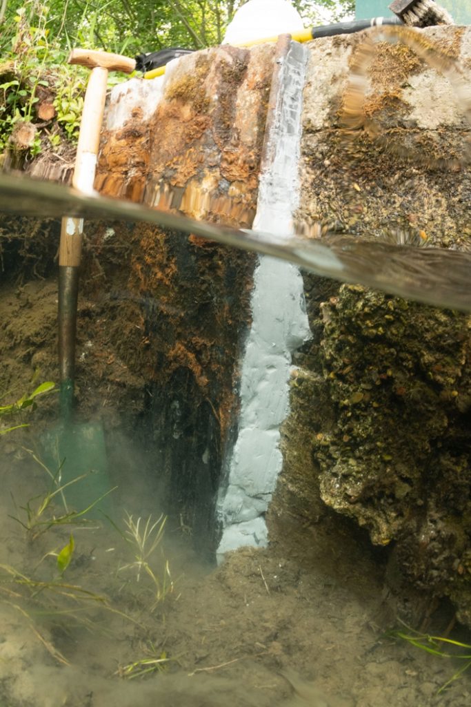 Sylmasta AB Original Epoxy Putty used to seal a crack in a concrete underwater river wall