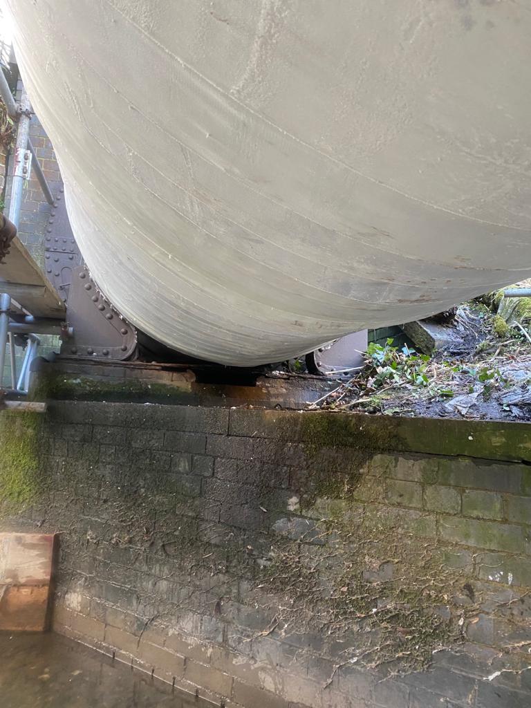 Underneath view of a pipe bridge traversing a river reinforced using SylWrap HD Pipe Repair Bandage