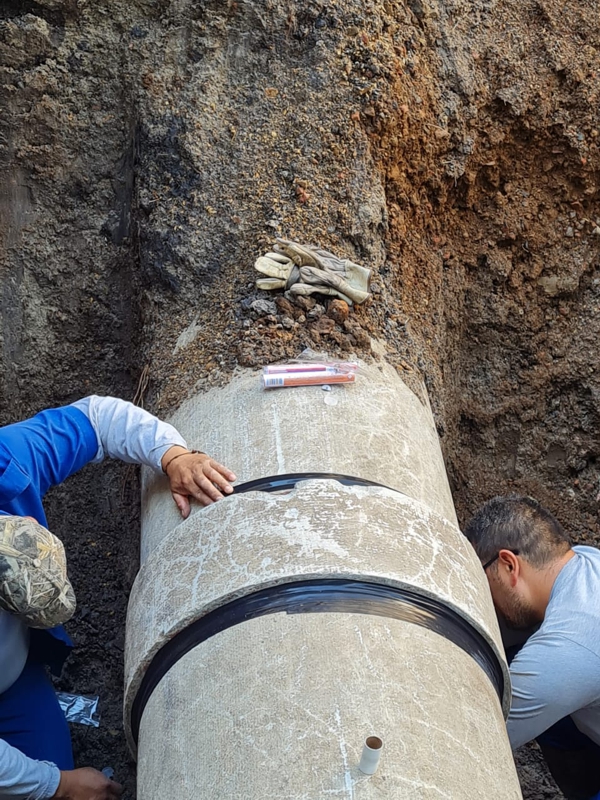 Wrap & Seal Pipe Burst Tape applied to seal a leaking sleeve as part of an asbestos cement pipe repair