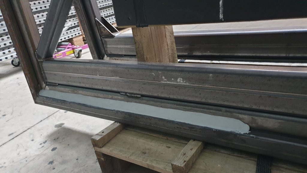 Sylmasta AB Original Epoxy Putty formed into a bevelled edge on a steel frame to help protection of wood gate from rot