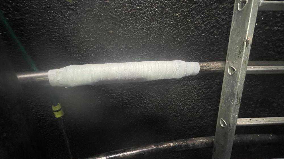 SylWrap HD reinforces a stainless steel heating pipe as part of a repair to a biodigester tank at a pig farm