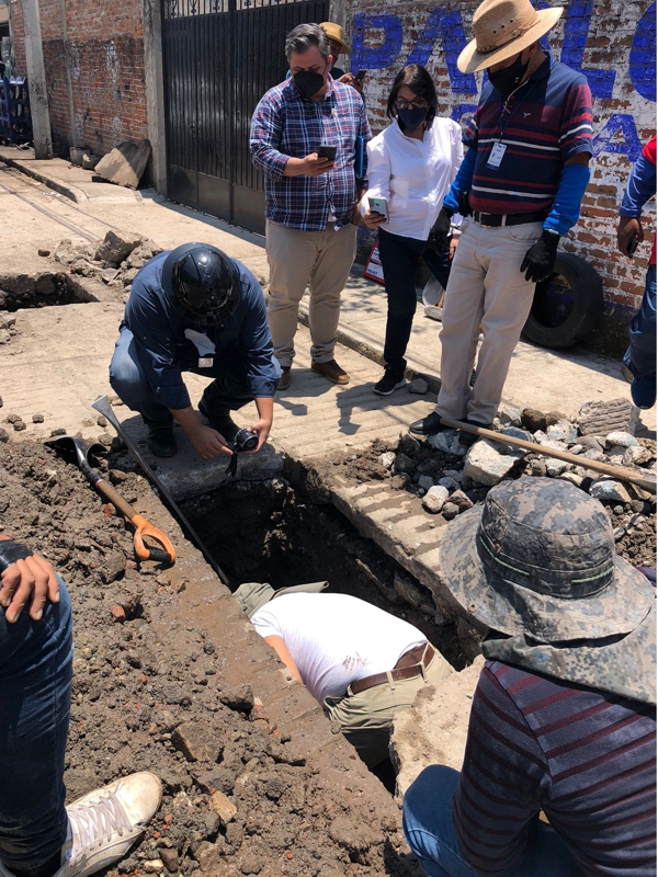 Engineer working in a hole to make a live leak pipe repair to the water network in Mexico