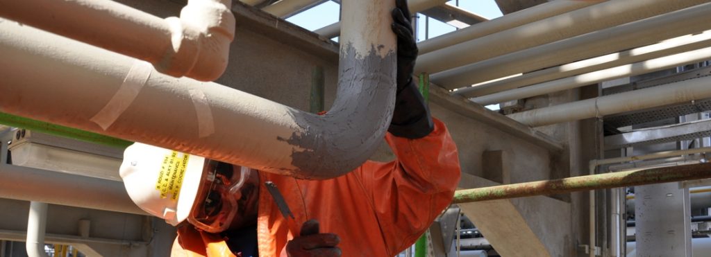 Industrial Metal Epoxy Paste being used to rebuild and repair a sulphuric acid line