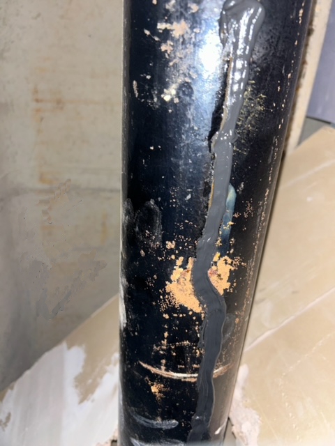 CrackSeal Sealant extruded directly into a split in a cast iron downpipe for a rapid repair