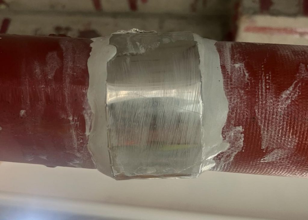 Sylmasta AB Original Epoxy Putty seals around a leaking pipe join in a cast iron rainwater stack repair