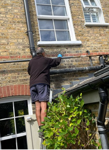 Contractors paint Liquid Metal Epoxy Coating onto a pipe during the repair of a shared water supply line in London