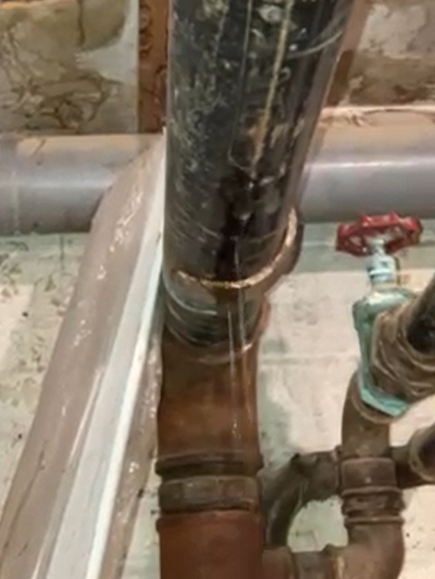 Heating pipe at a nursing home leaking before undergoing emergency repair with a SylWrap Universal Kit