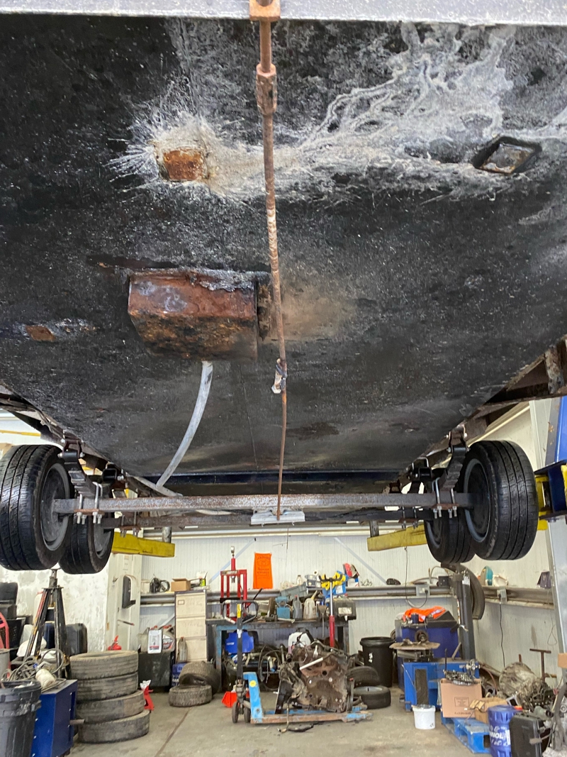 Heavily corroded wastewater holding tank underneath portable toilet trailer before repair