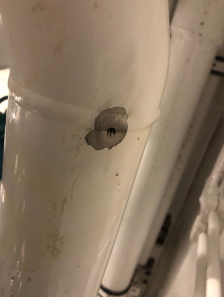 Corrosion causing a pinhole leak in a bilge pump system pipe before a SylWrap repair