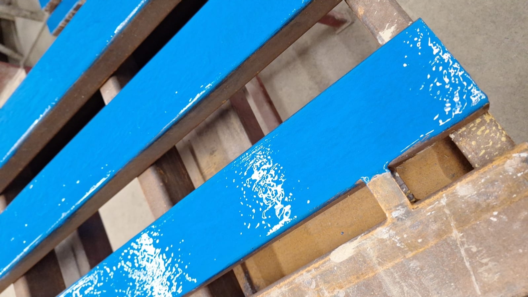 Metal pallet slats undergo repair and refurbishment using Ceramic Brushable Blue Epoxy Coating