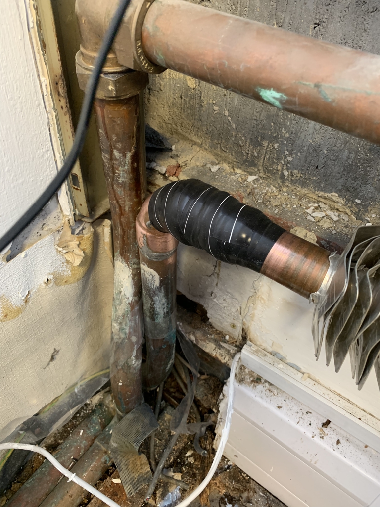 Domestic copper pipe leaking from a badly soldered joint undergoes repair using Wrap & Seal Pipe Burst Tape