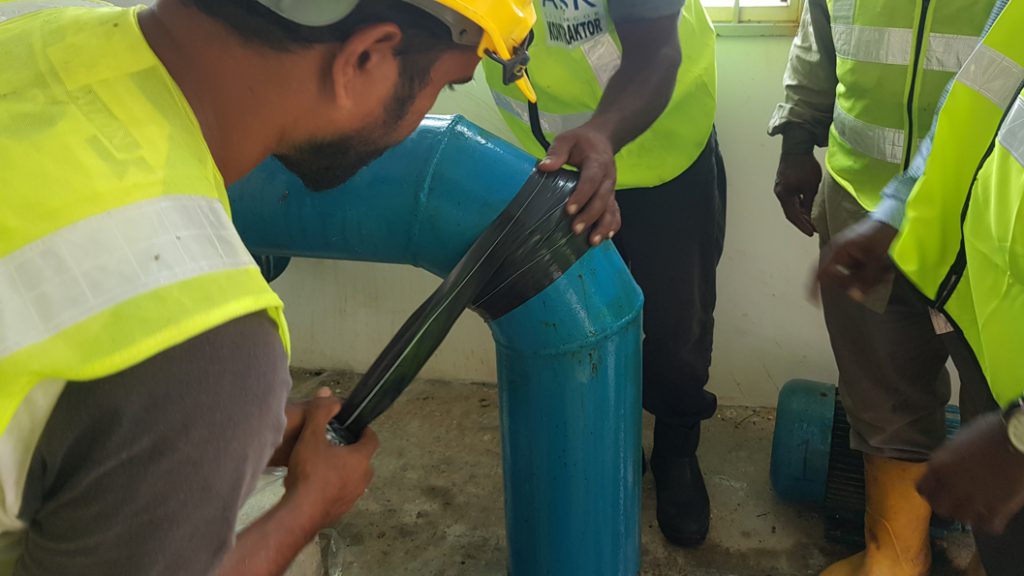 Wrap & Seal Pipe Burst Tape being used to repair a leaking elbow joint at a pumping house in Malaysia