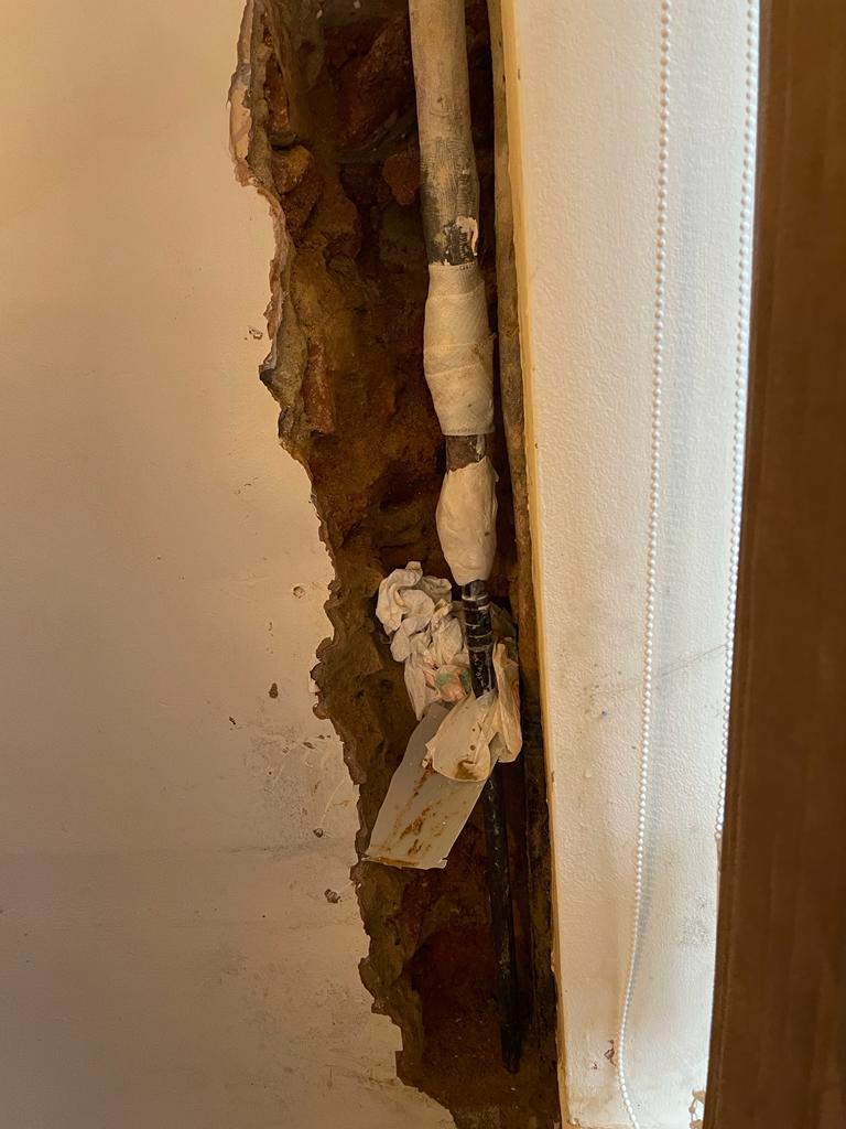 Completed repair of a lead water pipe leaking inside the wall of a UK home