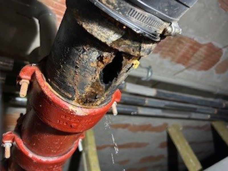 UK hospital needed a way to seal this 80mm diameter hole in cast iron drain pipe leaking wastewater